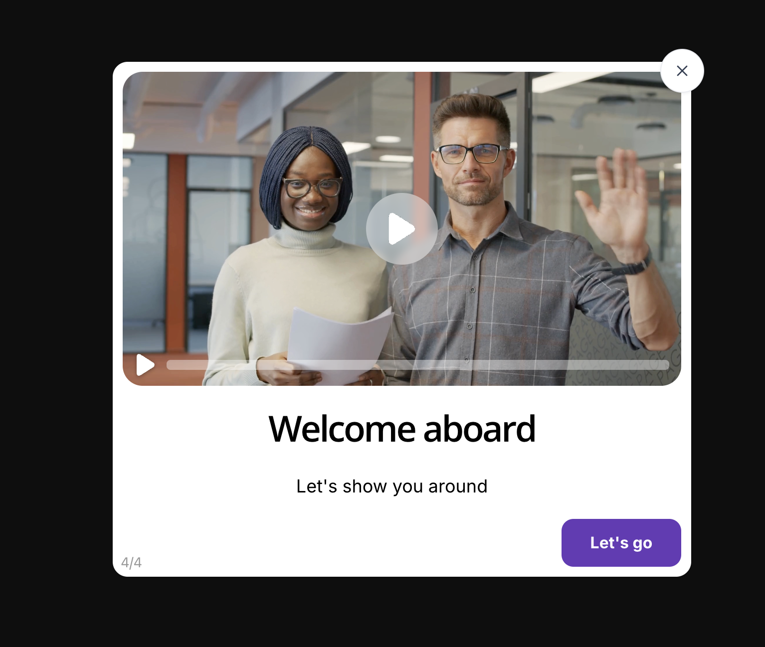 Product tour modal example showing a video onboarding modal with a thumbnail of two colleagues waving, a play button overlay, a progress bar at the bottom of the video, the headline 'Welcome aboard', a subtitle 'Let's show you around', and a purple 'Let's go' CTA button at step 4 of 4